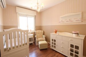 Crib, changing table, and other baby gear in a nursery